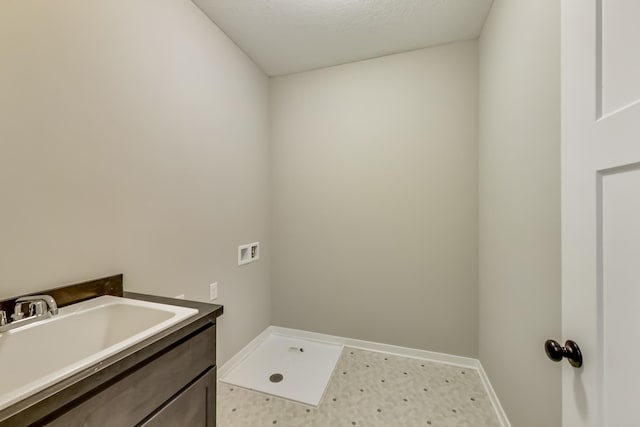 laundry room with a sink, baseboards, washer hookup, and laundry area