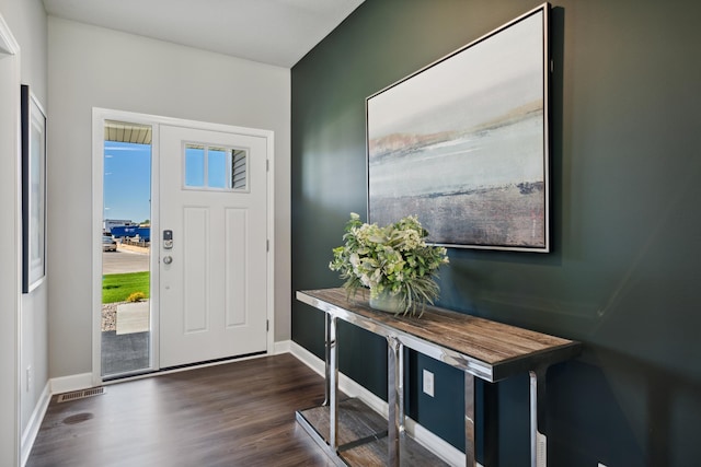 foyer entrance with visible vents, baseboards, and dark wood-type flooring