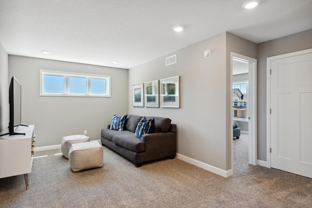 living room with carpet floors, visible vents, and baseboards