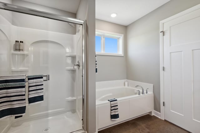 bathroom featuring a shower stall and a bath