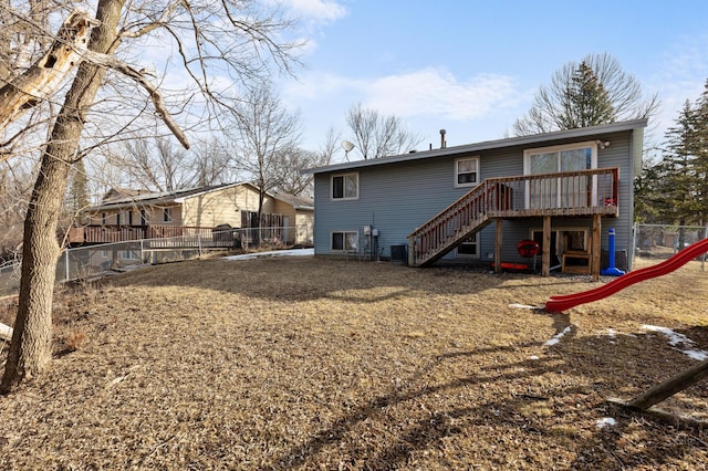 rear view of house featuring a deck, a fenced backyard, a playground, cooling unit, and stairs