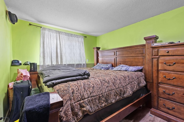 bedroom featuring wood finished floors and a textured ceiling