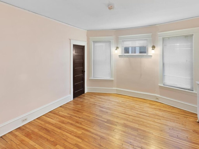 unfurnished room with baseboards and light wood-style floors