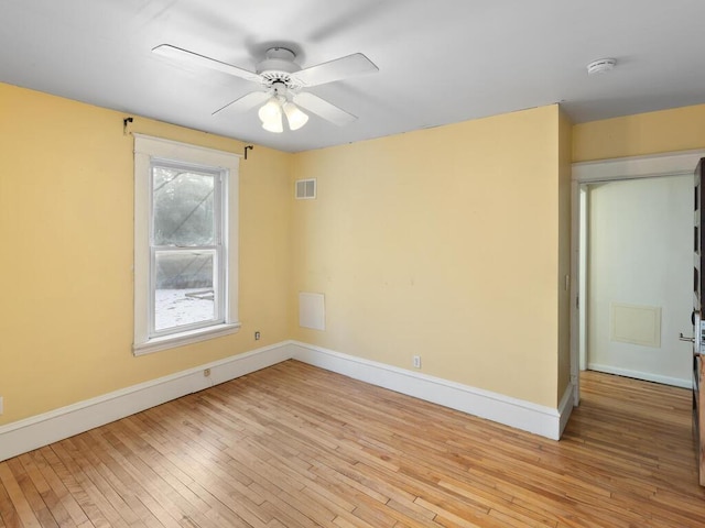 unfurnished room featuring light wood-type flooring, baseboards, visible vents, and a ceiling fan