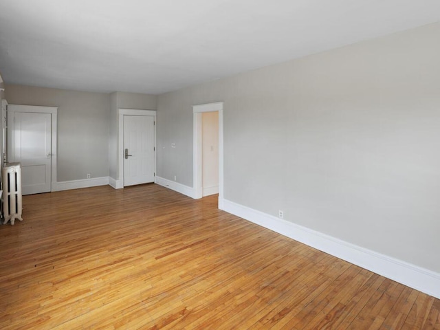 spare room featuring light wood-style floors and baseboards