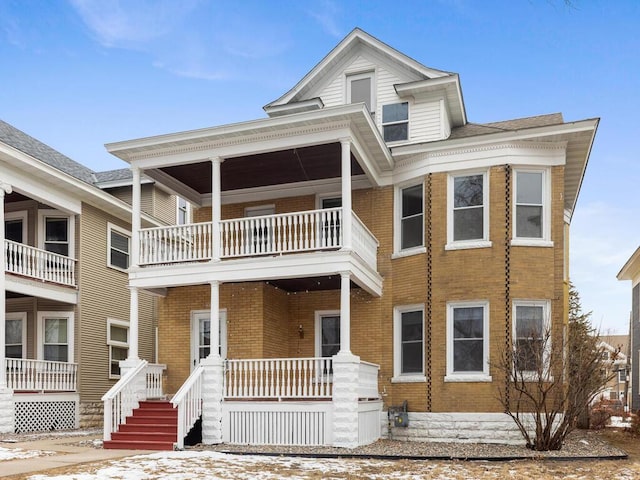 view of front of house featuring brick siding and a porch