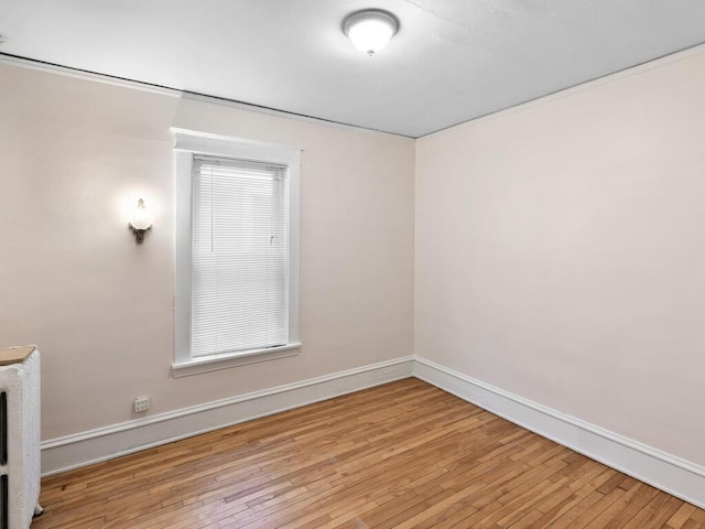 empty room with hardwood / wood-style floors and baseboards