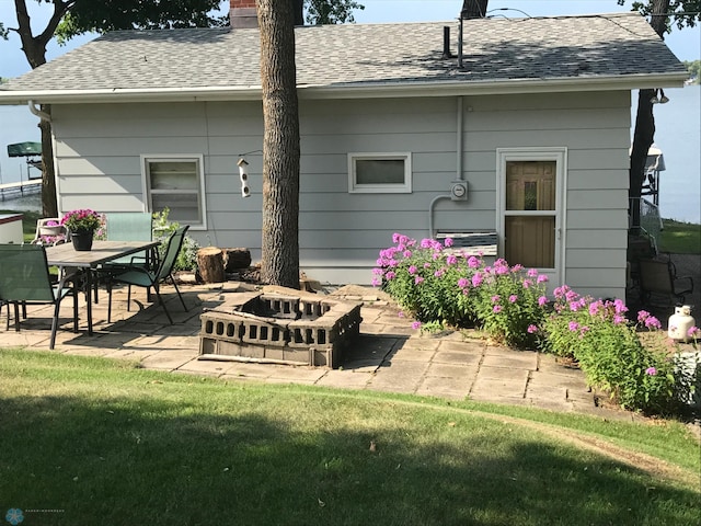 17140 Big Cormorant Rd, Lake Eunice Twp, MN 56511 - back of property with a patio area, a chimney, roof with shingles, a fire pit, and a lawn