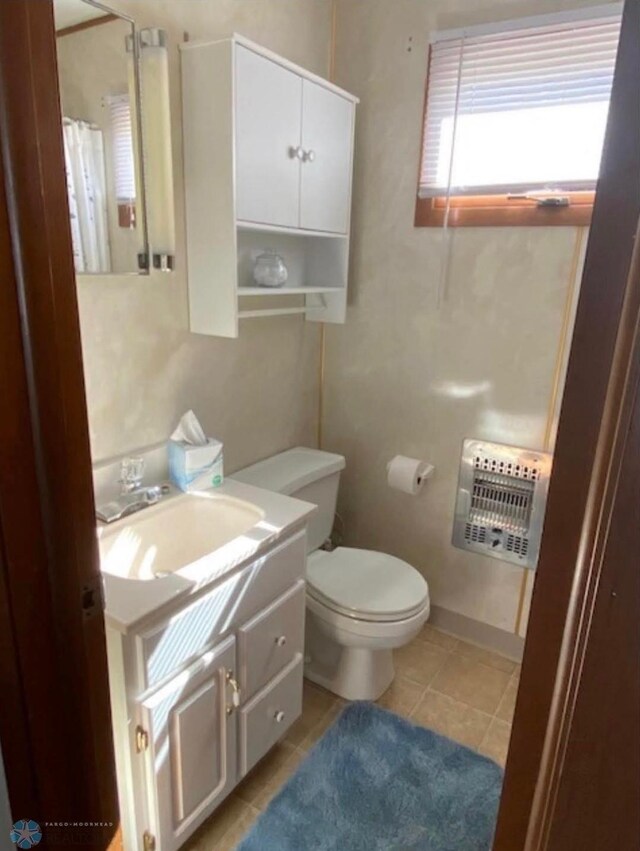 17140 Big Cormorant Rd, Lake Eunice Twp, MN 56511 - full bathroom featuring heating unit, vanity, toilet, tile patterned floors, and a shower with curtain