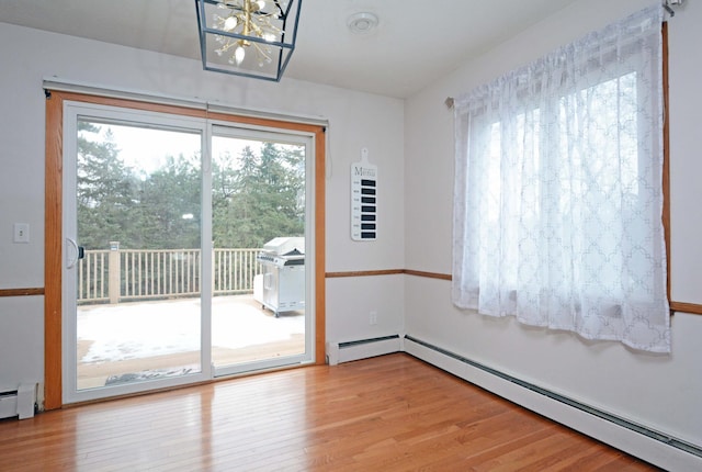 doorway with baseboard heating and wood finished floors