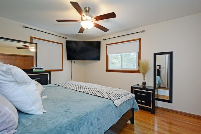 bedroom featuring ceiling fan, baseboards, and wood finished floors