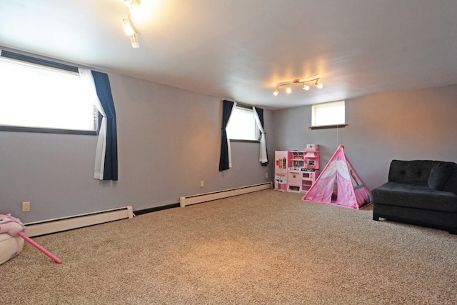 rec room with carpet floors, a baseboard heating unit, and track lighting