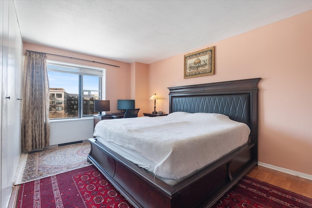 bedroom featuring baseboards and wood finished floors