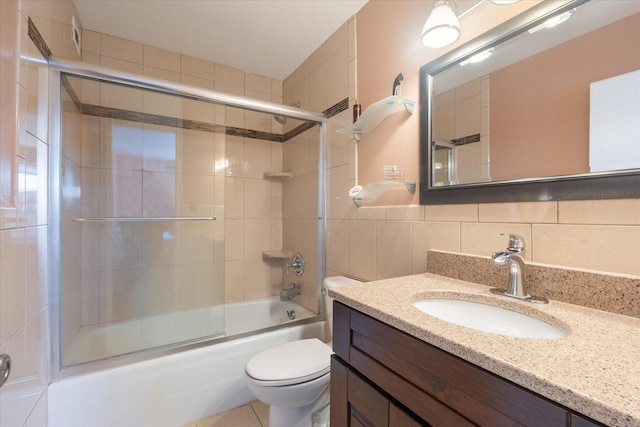 bathroom featuring shower / bath combination with glass door, tile walls, tasteful backsplash, toilet, and vanity