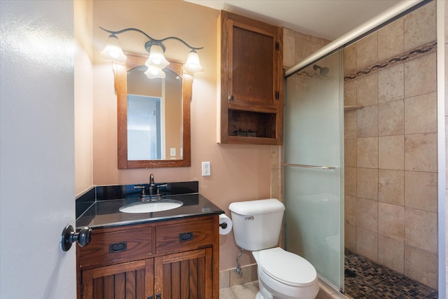 bathroom featuring a shower stall, toilet, and vanity