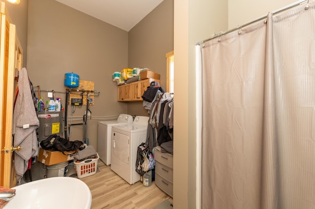 clothes washing area featuring light wood finished floors and washing machine and clothes dryer