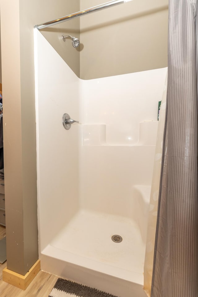 bathroom featuring a stall shower and wood finished floors