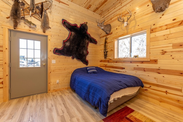 bedroom with wood ceiling, wooden walls, and wood finished floors