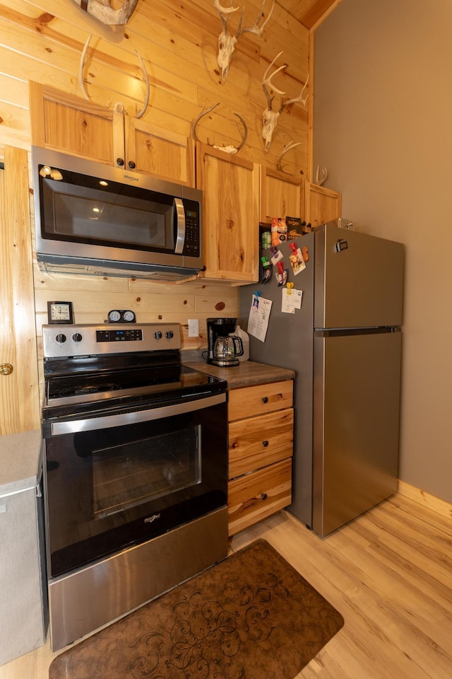 kitchen featuring light wood finished floors and appliances with stainless steel finishes