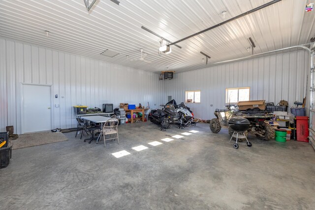 garage with metal wall, a workshop area, and a garage door opener