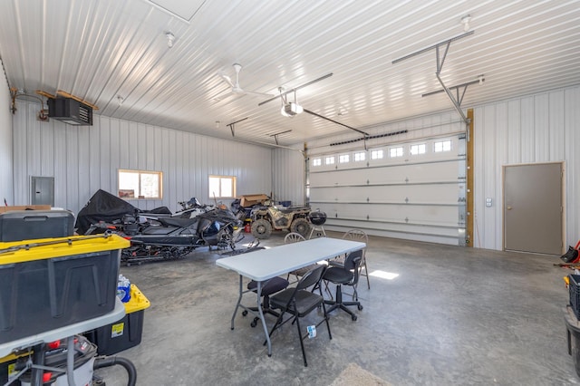 garage with electric panel, metal wall, and a garage door opener