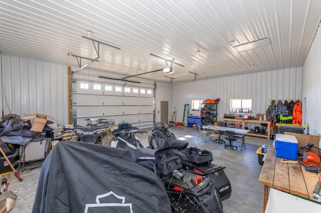 garage with a workshop area, metal wall, and a garage door opener