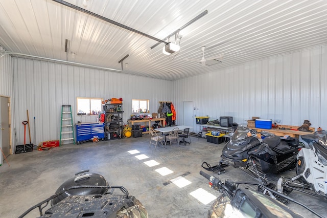 garage featuring a garage door opener, a workshop area, and metal wall