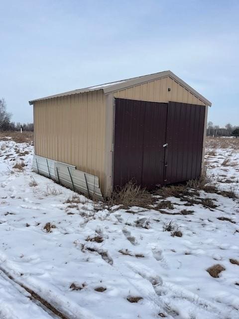 snow covered structure featuring an outdoor structure