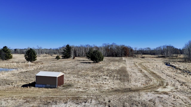 view of yard featuring a pole building, a rural view, and an outdoor structure