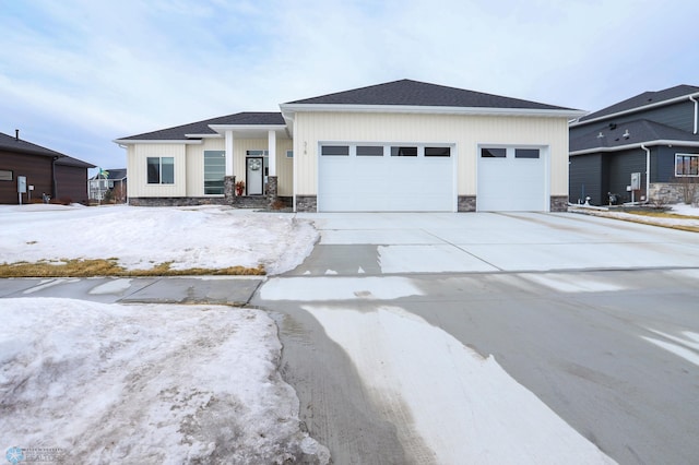 view of front of home with an attached garage, a shingled roof, stone siding, driveway, and board and batten siding