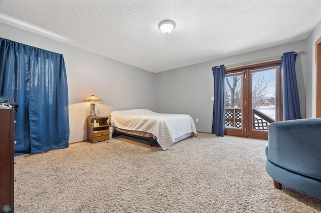 bedroom with access to outside, a textured ceiling, and carpet flooring