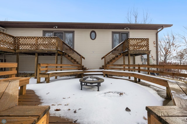 snow covered deck featuring an outdoor fire pit and stairs