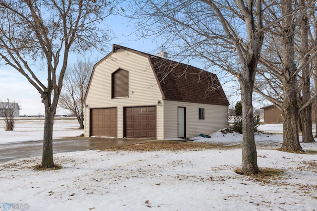 snow covered garage with a garage