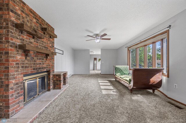 289 2nd St SW, Forman, ND 58032 - carpeted living room with a ceiling fan, a brick fireplace, baseboards, and a textured ceiling