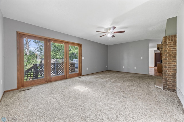 289 2nd St SW, Forman, ND 58032 - unfurnished living room featuring carpet flooring, a ceiling fan, baseboards, and a fireplace