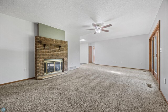 289 2nd St SW, Forman, ND 58032 - unfurnished living room featuring a ceiling fan, a textured ceiling, carpet flooring, a brick fireplace, and baseboards