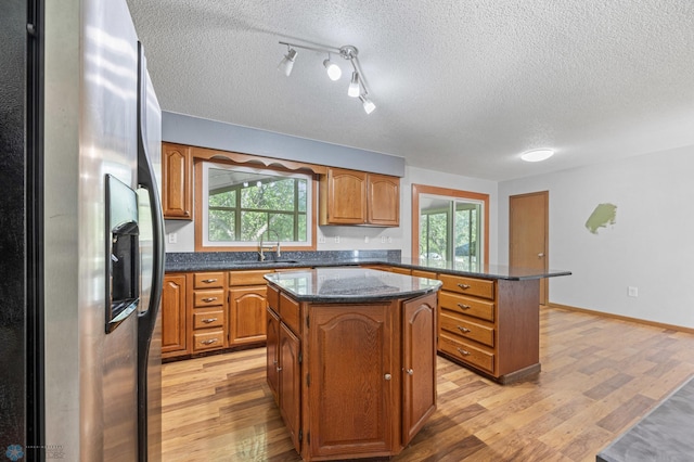 289 2nd St SW, Forman, ND 58032 - kitchen featuring stainless steel refrigerator with ice dispenser, a sink, a kitchen island, light wood-style flooring, and a peninsula