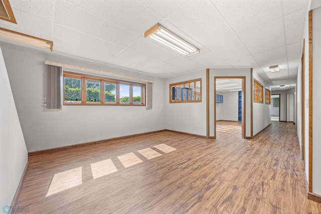 289 2nd St SW, Forman, ND 58032 - below grade area featuring a drop ceiling, wood finished floors, and baseboards