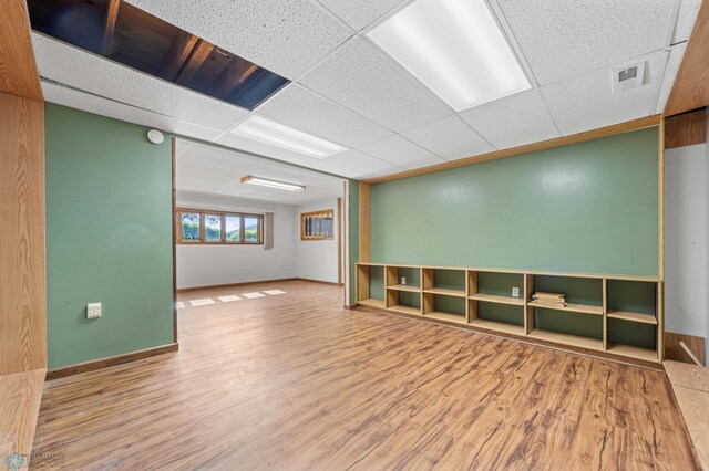 289 2nd St SW, Forman, ND 58032 - empty room featuring wood finished floors, a drop ceiling, and baseboards