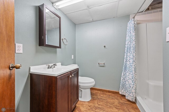 289 2nd St SW, Forman, ND 58032 - bathroom featuring wood finished floors, vanity, toilet, a shower with shower curtain, and a drop ceiling