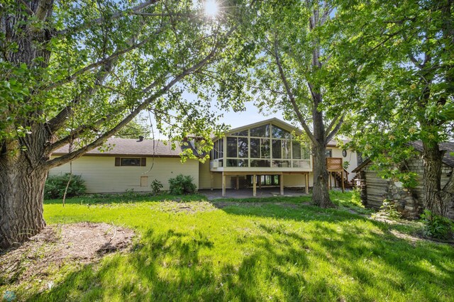 289 2nd St SW, Forman, ND 58032 - back of house with a sunroom, stairway, and a lawn