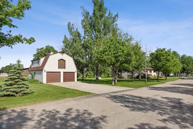 289 2nd St SW, Forman, ND 58032 - view of front of home featuring a gambrel roof, an attached garage, a front lawn, concrete driveway, and a chimney