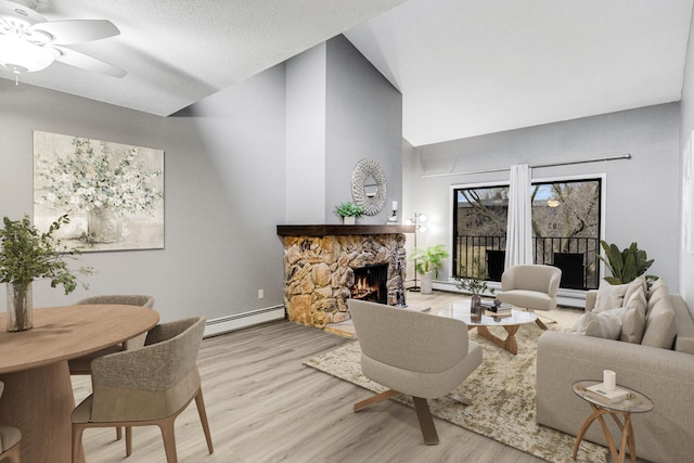 living room featuring a fireplace, a baseboard radiator, ceiling fan, a textured ceiling, and wood finished floors