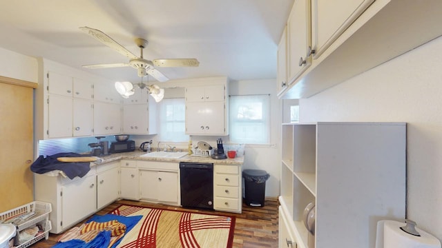 kitchen with wood finished floors, a sink, black appliances, white cabinets, and light countertops