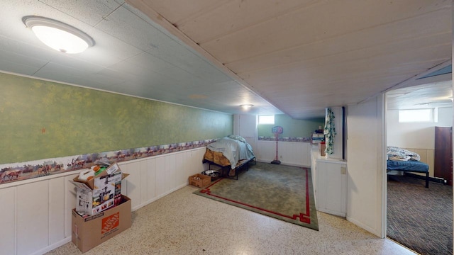 unfurnished bedroom featuring wainscoting and speckled floor