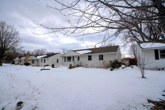 view of snow covered back of property