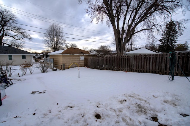 yard covered in snow featuring fence