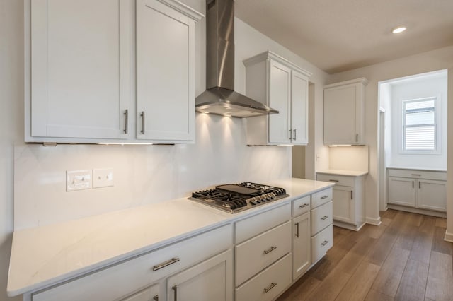 kitchen featuring light countertops, stainless steel gas cooktop, wall chimney exhaust hood, and wood finished floors