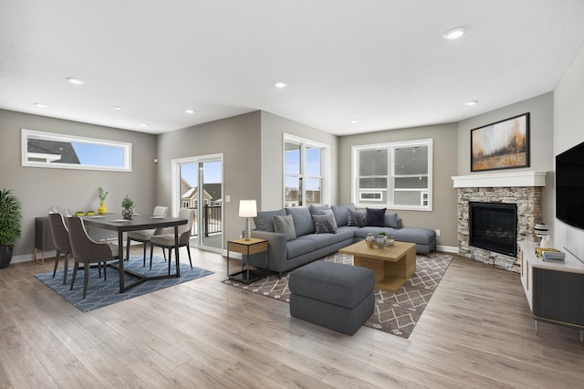 living room with light wood-style floors, recessed lighting, a fireplace, and baseboards