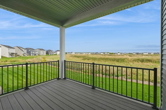 wooden terrace with a residential view and a lawn